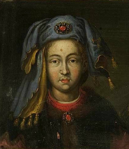 Bust-length oil portrait identified as Thibaut II, Duke of Lorraine: a young, beardless sitter in a blue-grey cap wound about the head, with a jewelled gold ornament set with a red stone at the front and veils falling to gold tassels at either side, wearing a red garment beneath a dark fur-collared robe with a second red jewelled brooch at the breast, against a dark ground